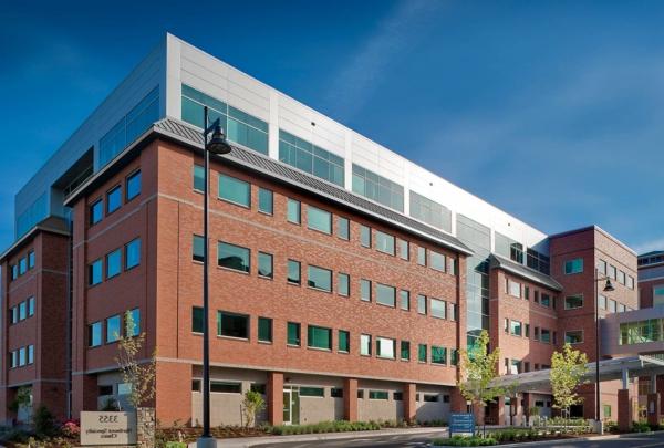 Exterior photo of the entrance at Northwest Specialty Center. Five level, red brick structure against bright blue skies. 新安装的景观环绕设施.